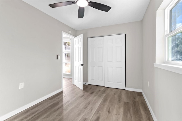 unfurnished bedroom featuring ceiling fan, light hardwood / wood-style floors, and a closet