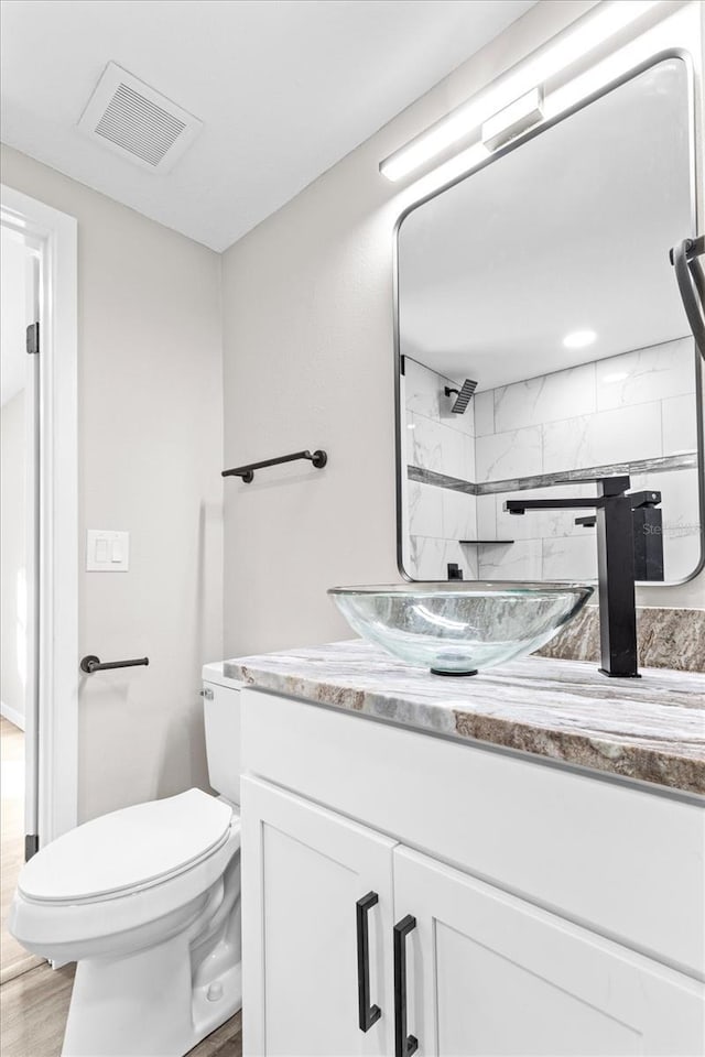 bathroom featuring vanity, hardwood / wood-style floors, and toilet