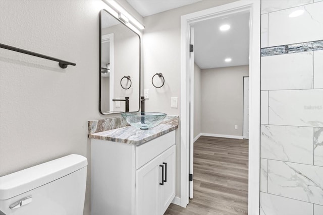 bathroom with hardwood / wood-style flooring, vanity, and toilet