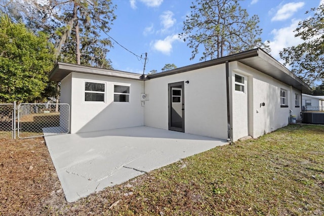 view of front of property featuring central AC unit, a patio area, and a front lawn