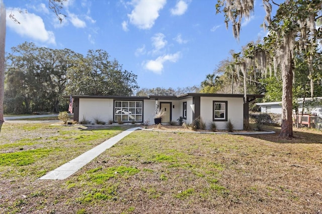 ranch-style home featuring a front lawn