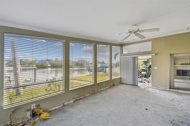 unfurnished sunroom with a water view and ceiling fan