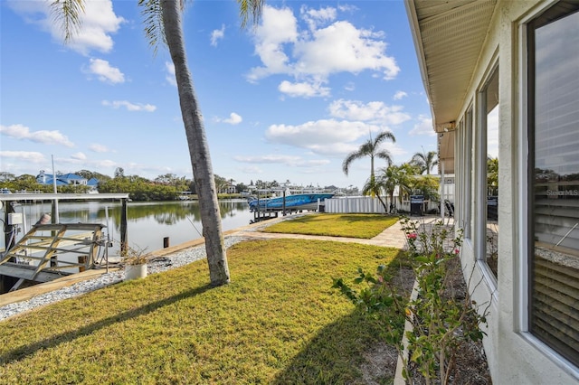 view of dock with a yard, a patio, and a water view