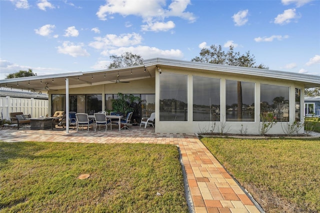 1897 Clearwater Harbor Dr, Largo, FL 33770 - back of house featuring a yard, ceiling fan, a patio area, and an outdoor fire pit