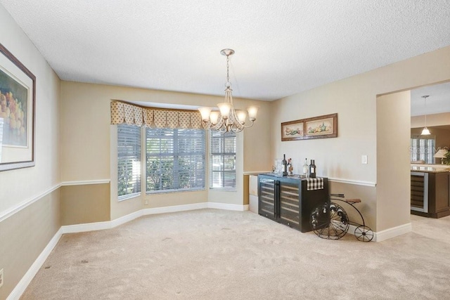 dining space with an inviting chandelier, bar, light carpet, and a textured ceiling