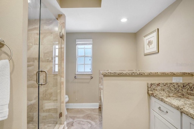 bathroom with vanity, a shower with shower door, and toilet