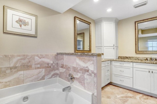 bathroom with vanity and a tub