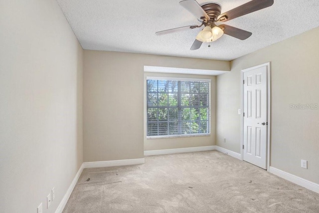 carpeted empty room featuring ceiling fan and a textured ceiling