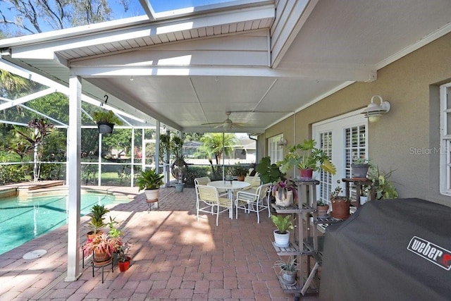 view of patio / terrace featuring ceiling fan, area for grilling, and glass enclosure