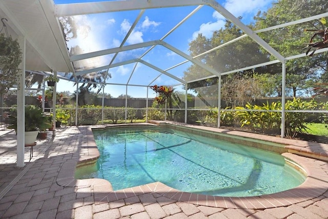 view of pool with a patio area and glass enclosure