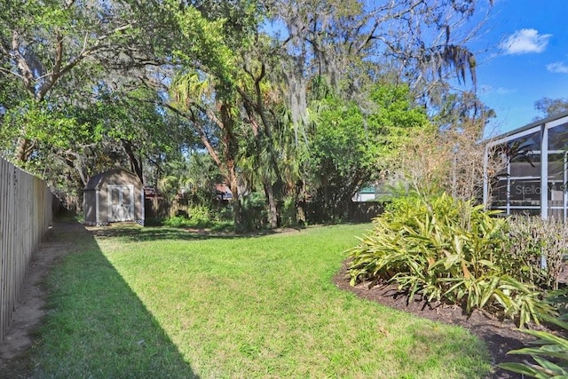 view of yard featuring a lanai and a shed