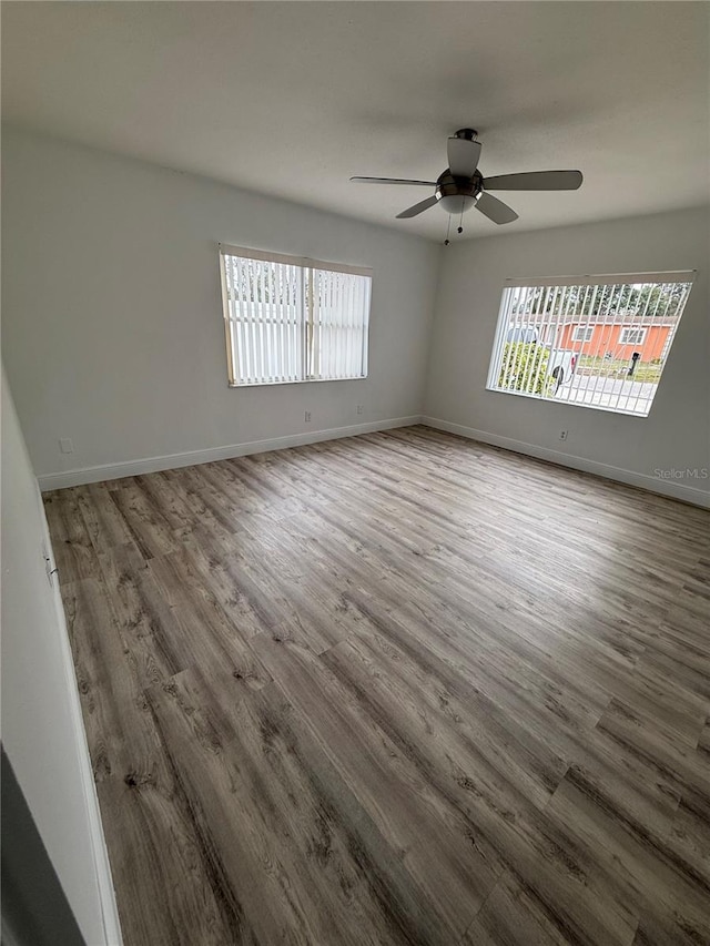 unfurnished room featuring hardwood / wood-style flooring, ceiling fan, and a healthy amount of sunlight