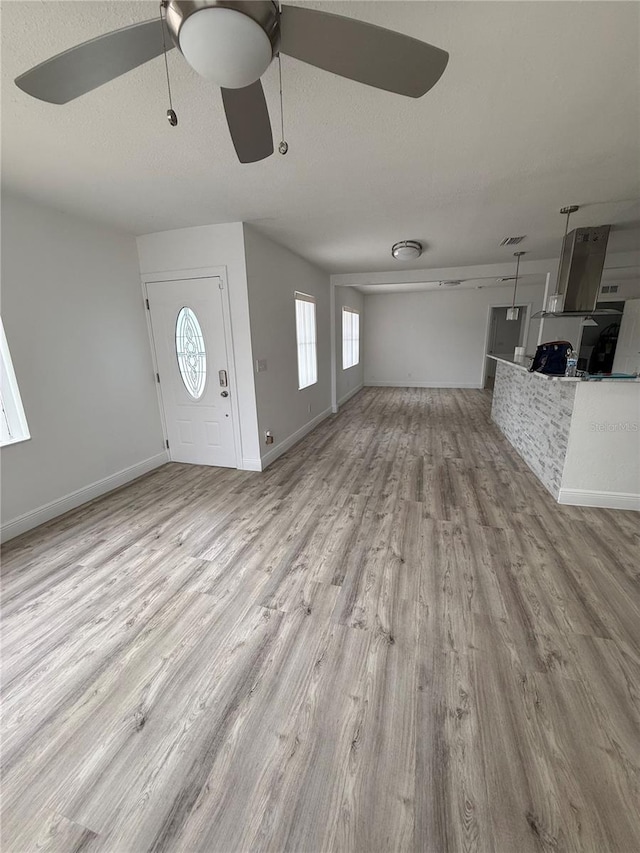 entrance foyer featuring ceiling fan, light hardwood / wood-style floors, and a textured ceiling