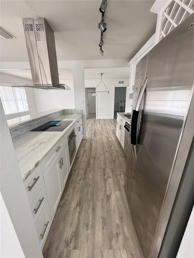 kitchen with island range hood, pendant lighting, stainless steel appliances, light stone countertops, and white cabinets