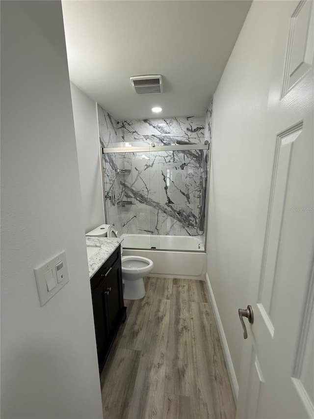 full bathroom featuring toilet, vanity, shower / bath combination with glass door, and wood-type flooring