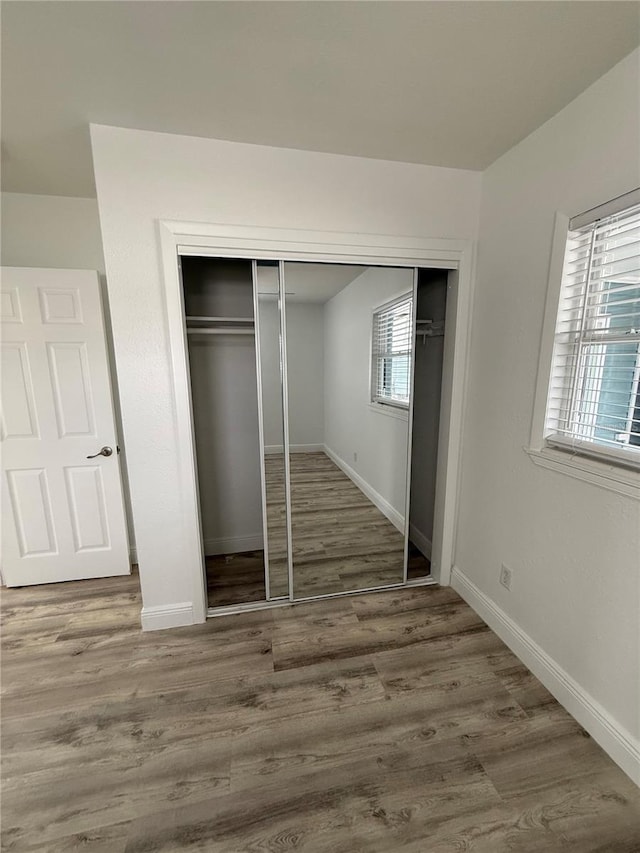 unfurnished bedroom with hardwood / wood-style flooring and a closet