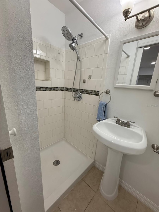 bathroom featuring tiled shower and tile patterned flooring