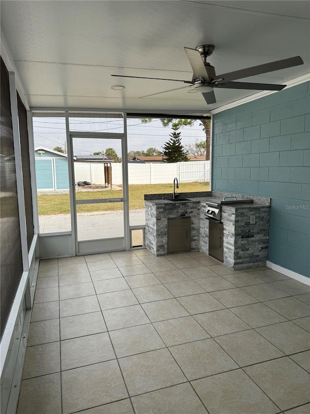 unfurnished sunroom featuring ceiling fan and sink