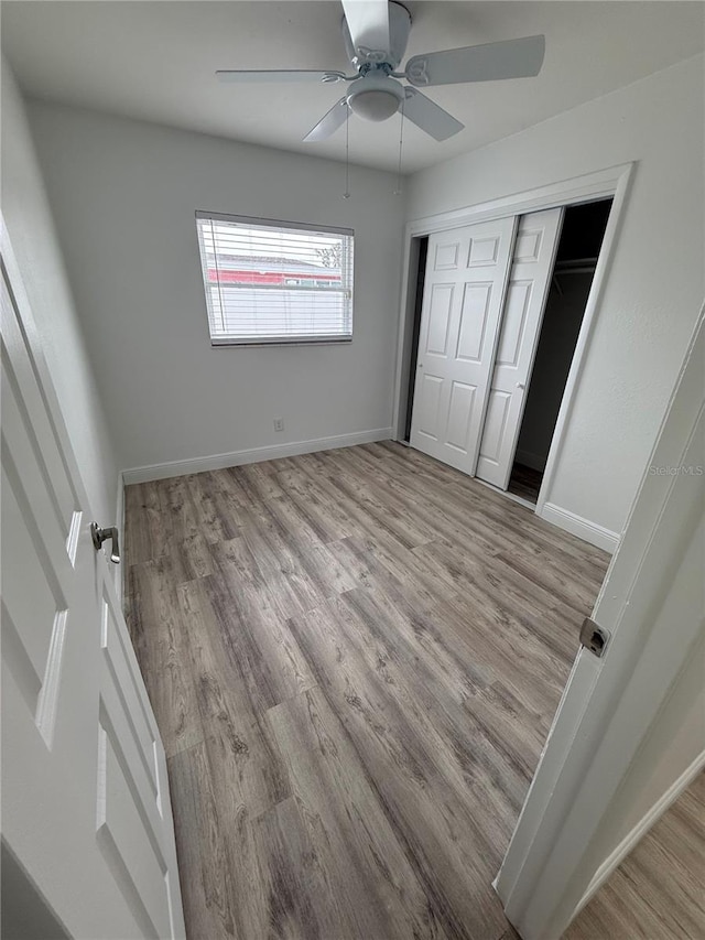 unfurnished bedroom with ceiling fan, light hardwood / wood-style floors, and a closet