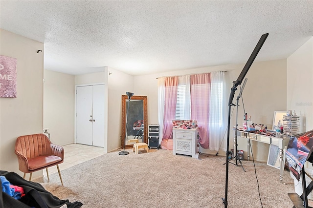 rec room featuring light carpet and a textured ceiling