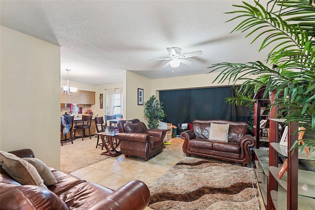 tiled living room with ceiling fan with notable chandelier and a textured ceiling