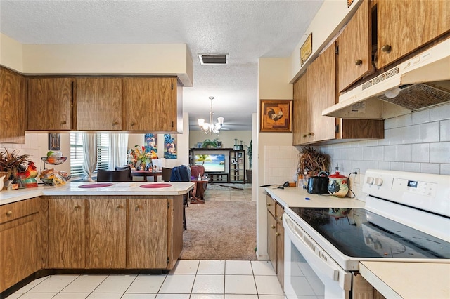 kitchen with hanging light fixtures, a notable chandelier, backsplash, and white electric range oven