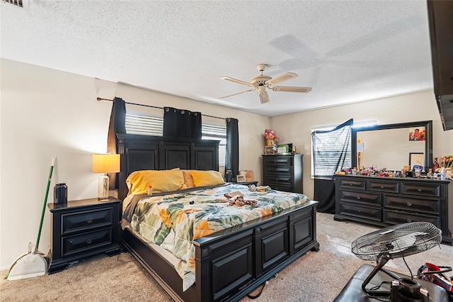 bedroom featuring multiple windows, ceiling fan, light carpet, and a textured ceiling