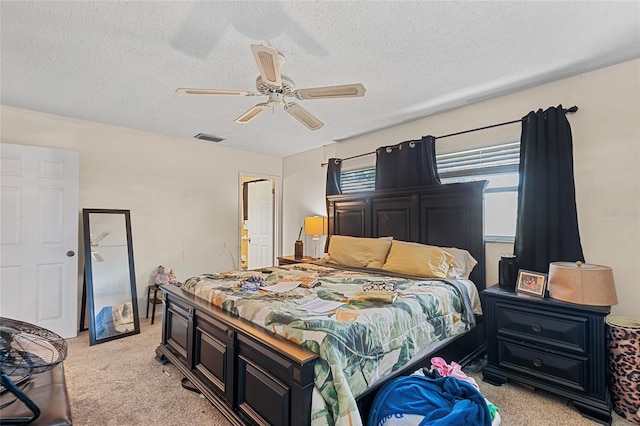 bedroom with light carpet, ceiling fan, and a textured ceiling