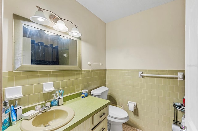 bathroom with tile patterned floors, vanity, toilet, and tile walls