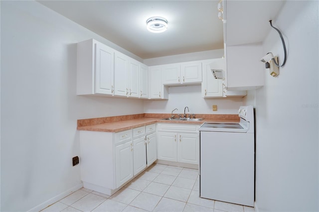 kitchen with washer / dryer, sink, light tile patterned floors, and white cabinets