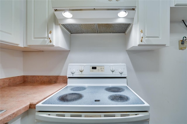 kitchen featuring electric stove, exhaust hood, and white cabinets