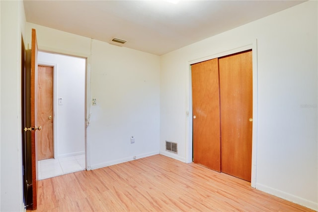 unfurnished bedroom with a closet and light hardwood / wood-style flooring