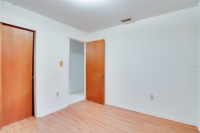 empty room with light hardwood / wood-style flooring