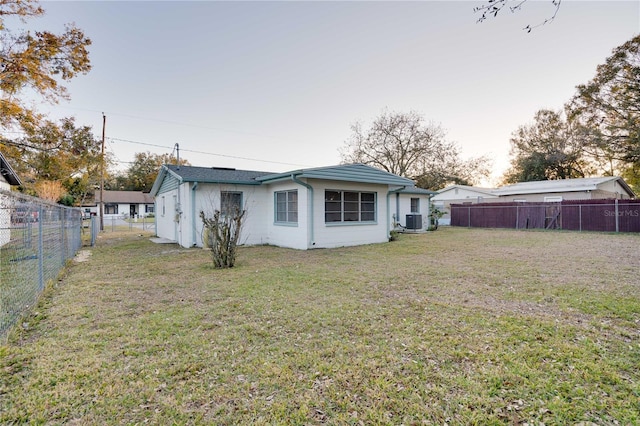 back of house featuring a yard and central AC unit