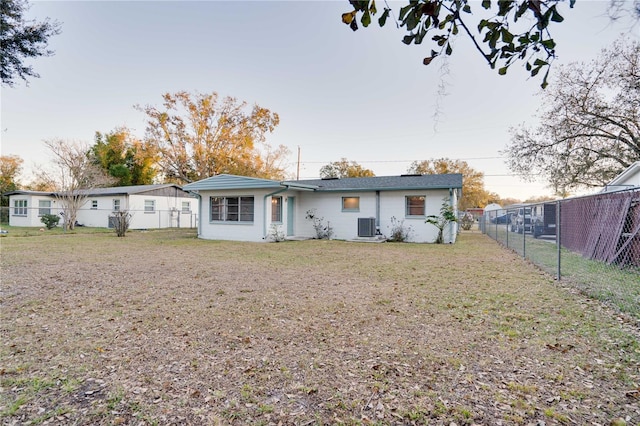 back of property with a yard and central air condition unit