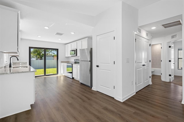 kitchen featuring appliances with stainless steel finishes, dark hardwood / wood-style floors, white cabinetry, sink, and light stone counters