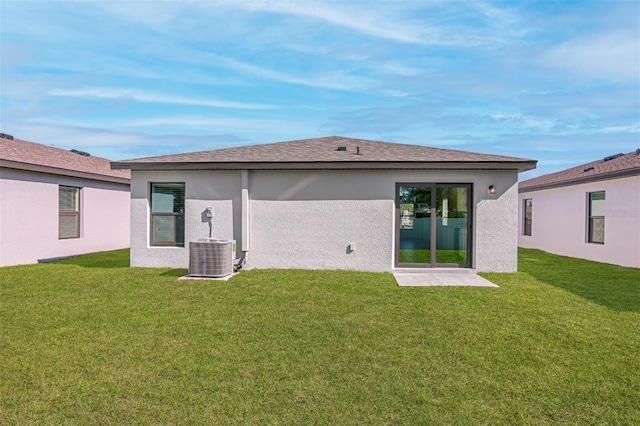 back of property featuring a lawn and central air condition unit