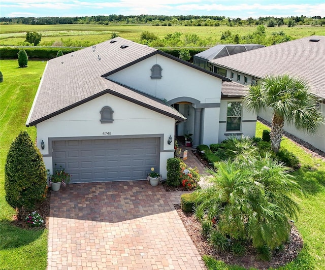 4748 Ballast Crest Cv, Land O Lakes, FL 34638 - view of front of home featuring stucco siding, an attached garage, and decorative driveway