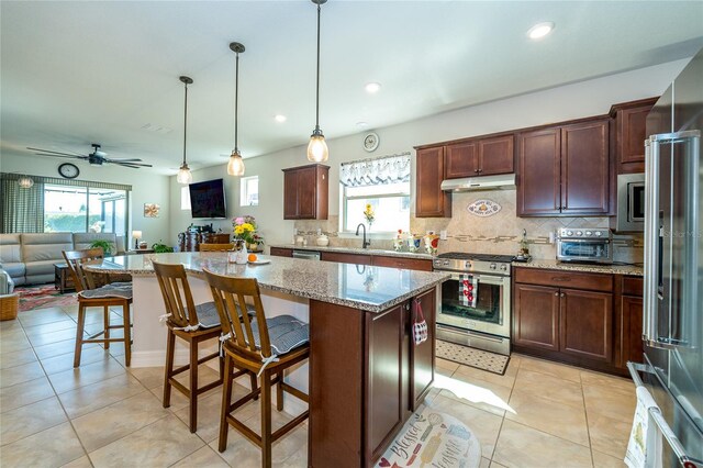 4748 Ballast Crest Cv, Land O Lakes, FL 34638 - kitchen featuring appliances with stainless steel finishes, open floor plan, under cabinet range hood, tasteful backsplash, and recessed lighting