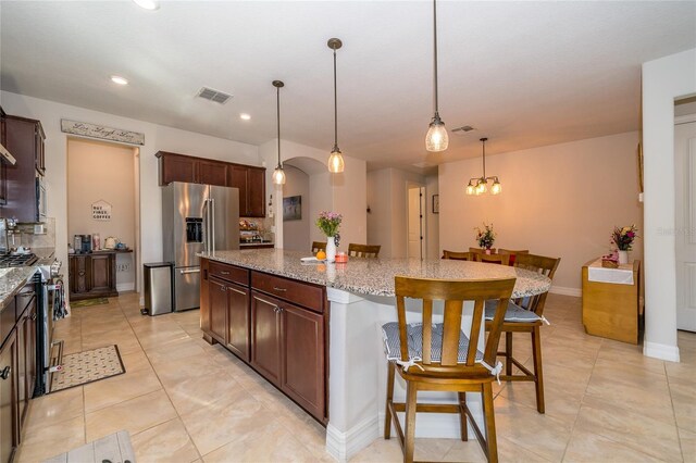 4748 Ballast Crest Cv, Land O Lakes, FL 34638 - kitchen featuring appliances with stainless steel finishes, a kitchen island, a kitchen bar, light stone countertops, and recessed lighting