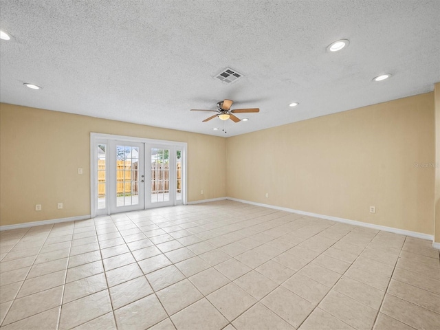 tiled spare room featuring ceiling fan, french doors, and a textured ceiling