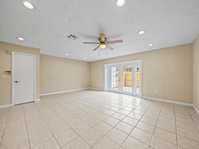 tiled empty room featuring a textured ceiling, ceiling fan, and french doors