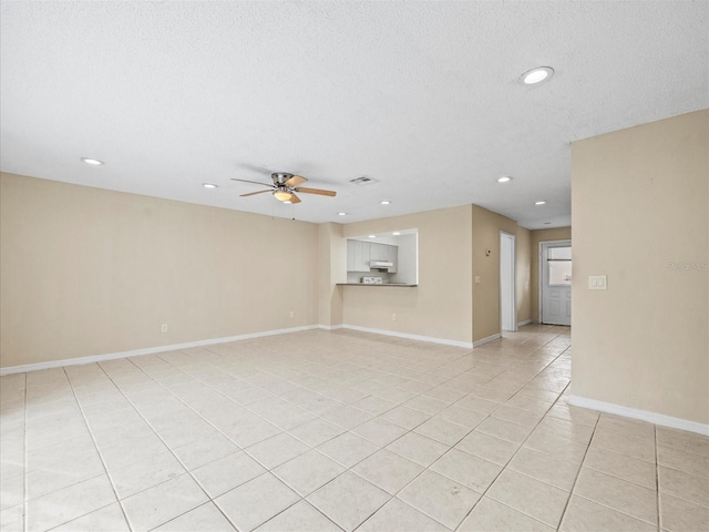 spare room with light tile patterned floors, a textured ceiling, and ceiling fan