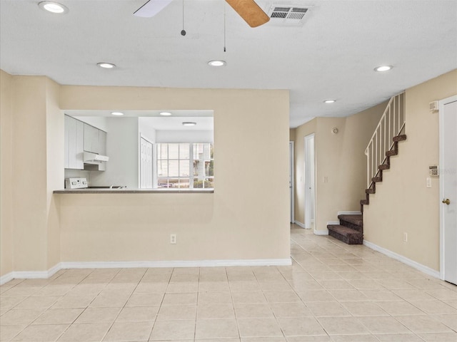 unfurnished living room with ceiling fan and light tile patterned floors