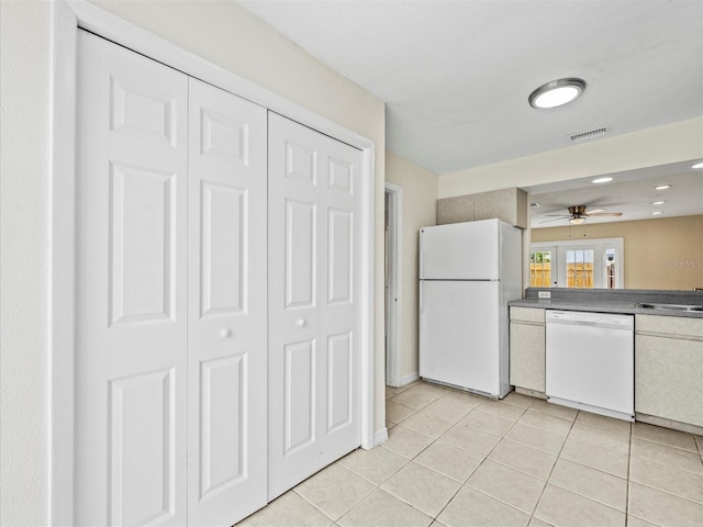 kitchen featuring white appliances, sink, and light tile patterned floors