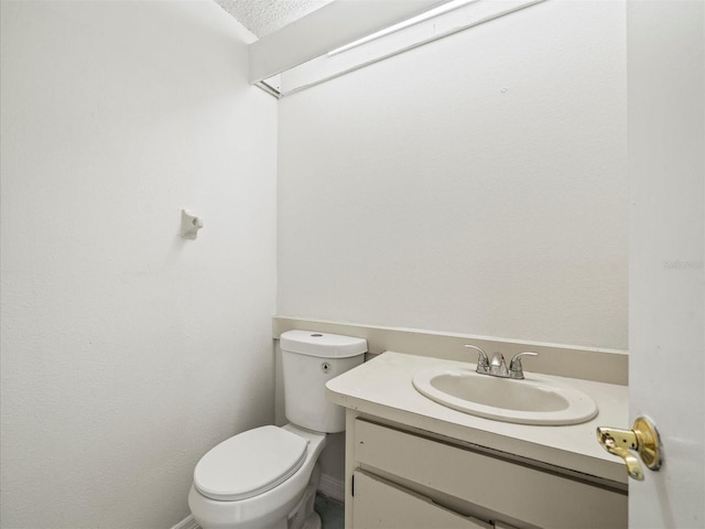 bathroom with vanity, a textured ceiling, and toilet