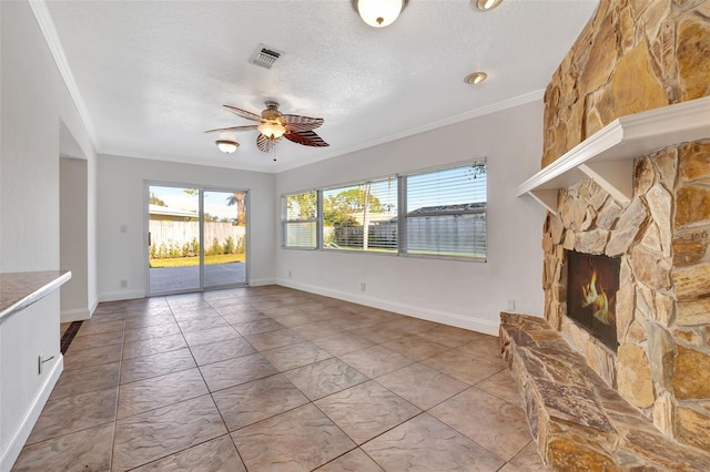 unfurnished living room with ornamental molding, ceiling fan, a textured ceiling, and a fireplace