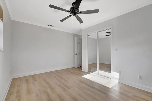 unfurnished bedroom featuring crown molding, ceiling fan, a closet, and light hardwood / wood-style flooring