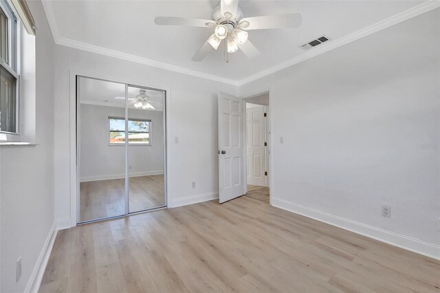 unfurnished bedroom featuring ornamental molding, a closet, ceiling fan, and light hardwood / wood-style flooring