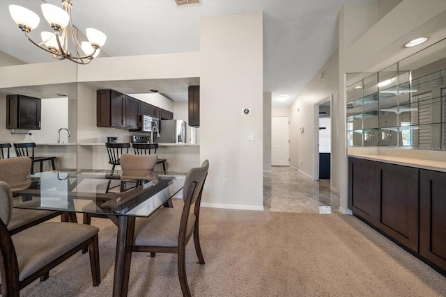 carpeted dining area with sink and an inviting chandelier